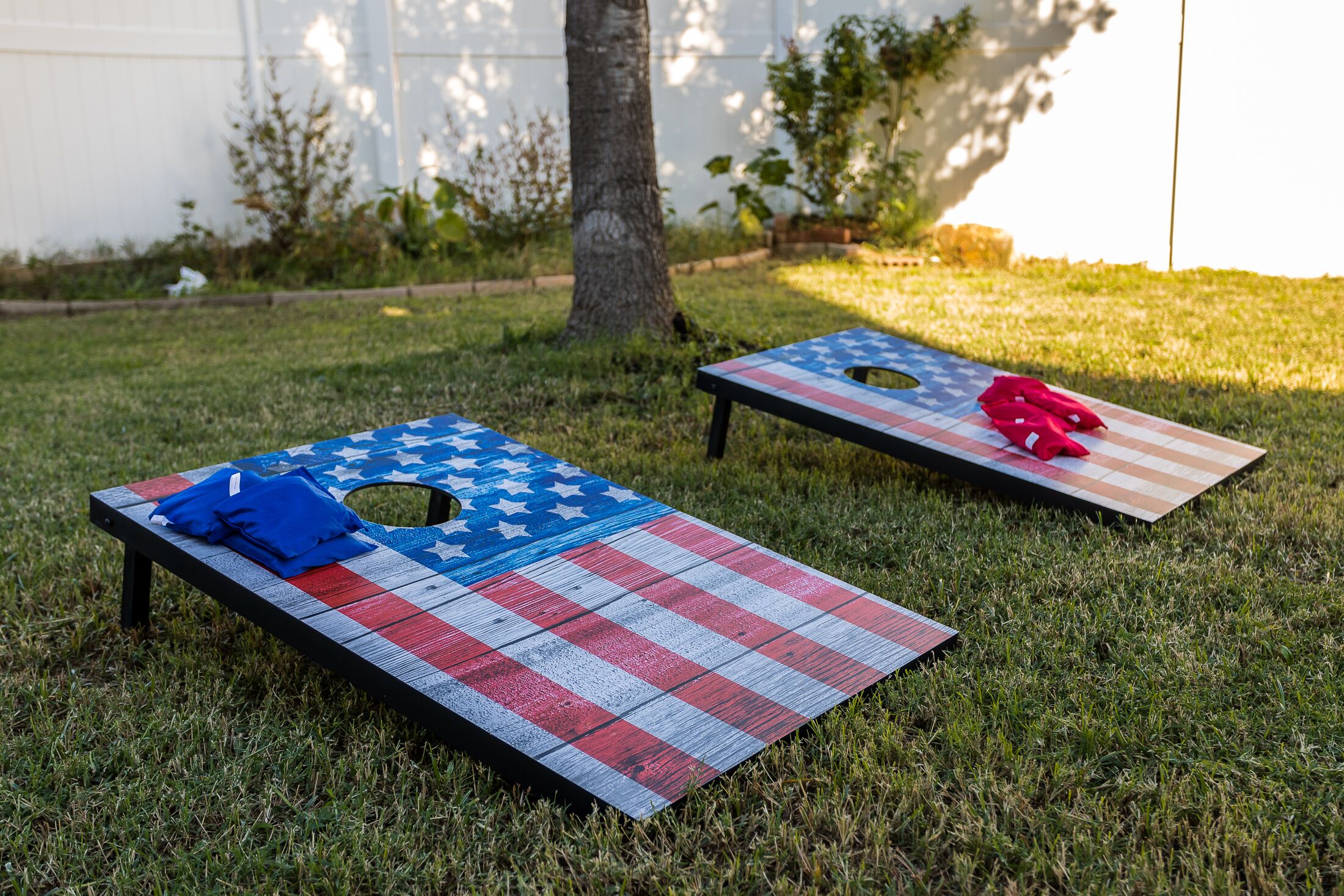 Two American flag-themed tables on a grassy lawn.