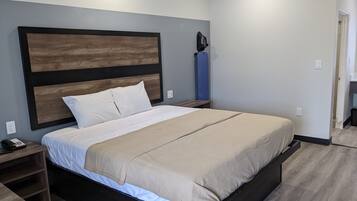 Un dormitorio moderno con una cama grande, cabecera de madera, mesitas de noche y un armario empotrado.