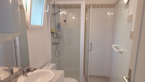A bathroom with a sink, toilet, and shower area. - Maison Petit Jardin au Calme Parking (Afa)