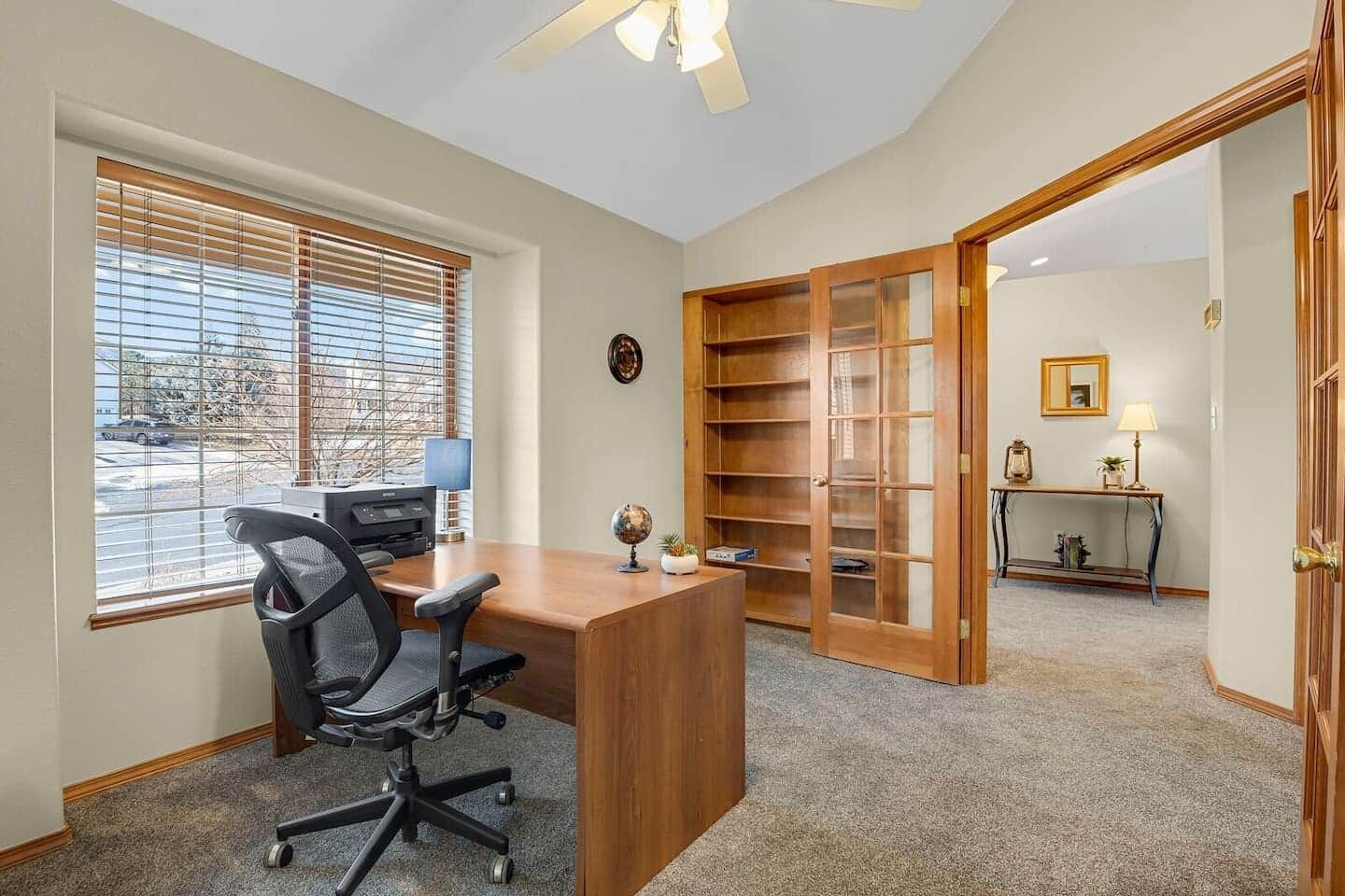 A home office with a desk, chair, and bookshelf.
