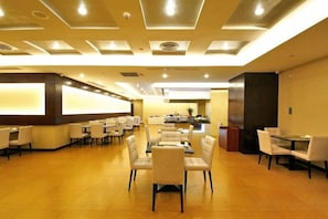 A hotel lobby with a reception desk, multiple seating areas, and a bar. - Huajun Hotel (Xiamen)
