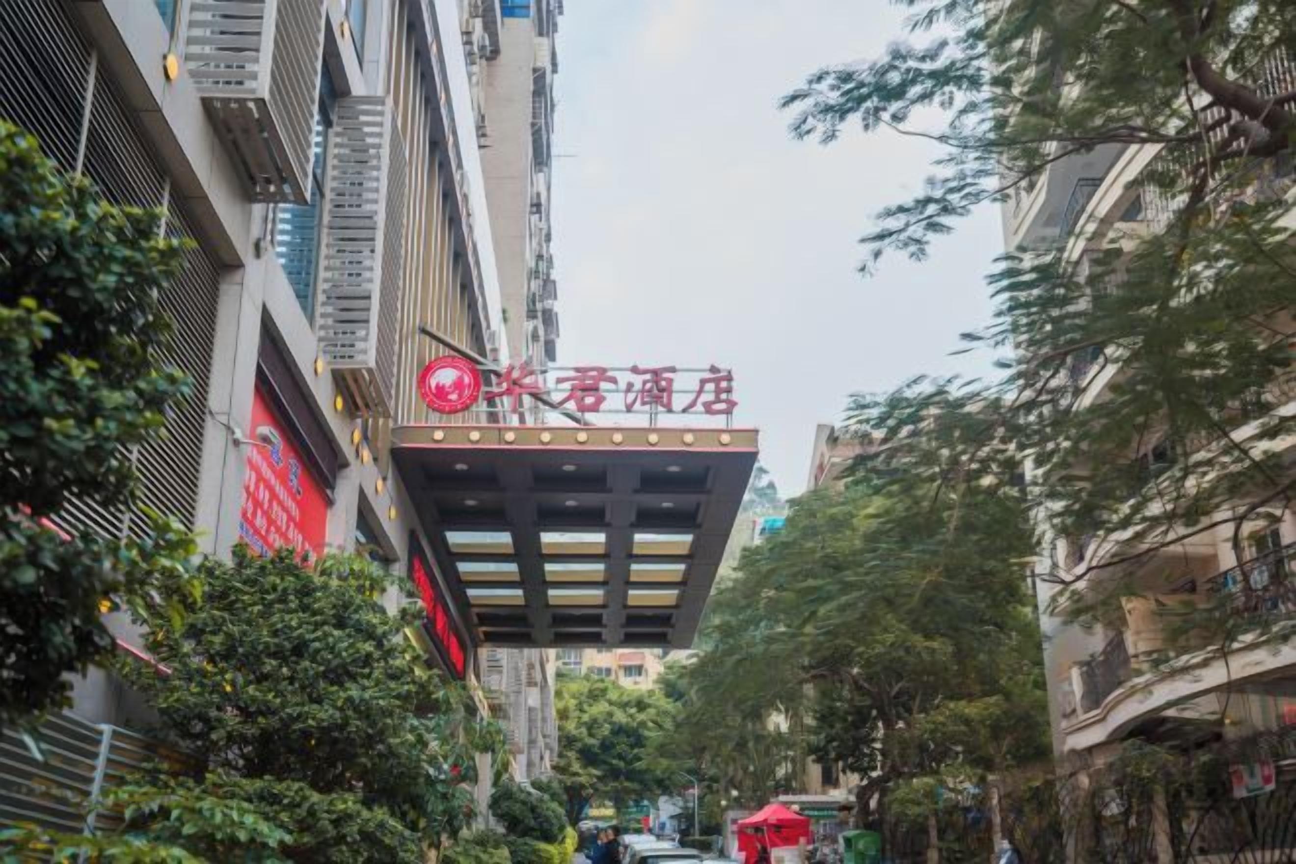 A narrow street with a building featuring a prominent red sign.
