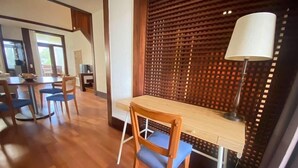 Un comedor con una mesa y sillas de madera, una lámpara y un panel decorativo de madera.