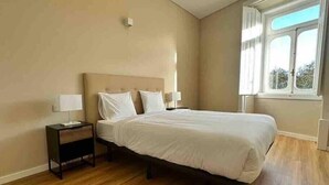 Une chambre à coucher avec un lit, deux tables de chevet et une fenêtre.