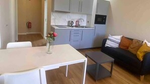 A compact living space with a kitchenette, a dining table, and a sofa. - Setúbal Prime III (Setúbal)