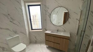 A bathroom with a toilet, sink, and mirror. - Setúbal Prime III (Setúbal)
