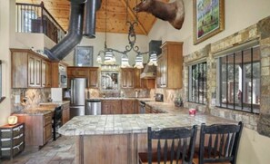 Enjoy cooking in this well-equipped kitchen with a large island, modern appliances, and a large window offering a view of the outdoors.