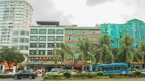 Un edificio de varios pisos con diseño moderno, que combina espacios comerciales y residenciales.