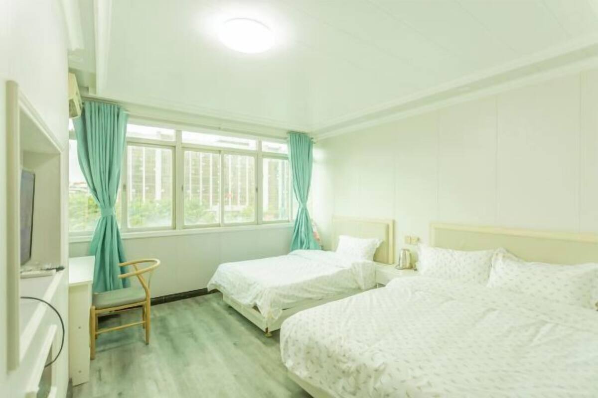 A room with two beds, a desk, and a chair.