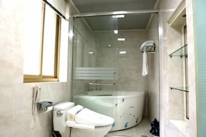 Casa de banho compacta com sanita, cabine de duche com divisória de vidro e uma janela pequena.