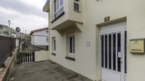 A building with a flat facade, a gated entrance, and a small sign indicating the number 10. - Cosy and Bright in La Arena Beach (Zierbena)