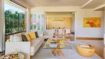 A modern living room with a sofa, coffee table, and dining area.