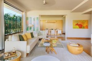 A modern living room with a sofa, coffee table, and dining area.