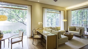 A modern living room with a sofa, armchair, dining table, and a ceiling fan. - Six Senses Vana - A Wellness Retreat (Dehradun)