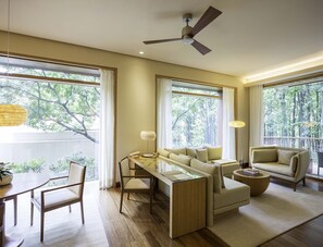 Una sala de estar moderna con un sofá, un sillón, una mesa de comedor y un ventilador de techo.
