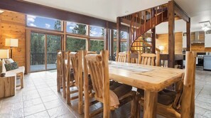 Enjoy meals in the dining area with a large table and comfortable chairs, surrounded by a modern kitchen and a spiral staircase.