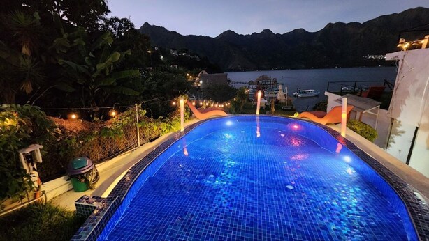 Piscina con vistas a montañas y una masa de agua.