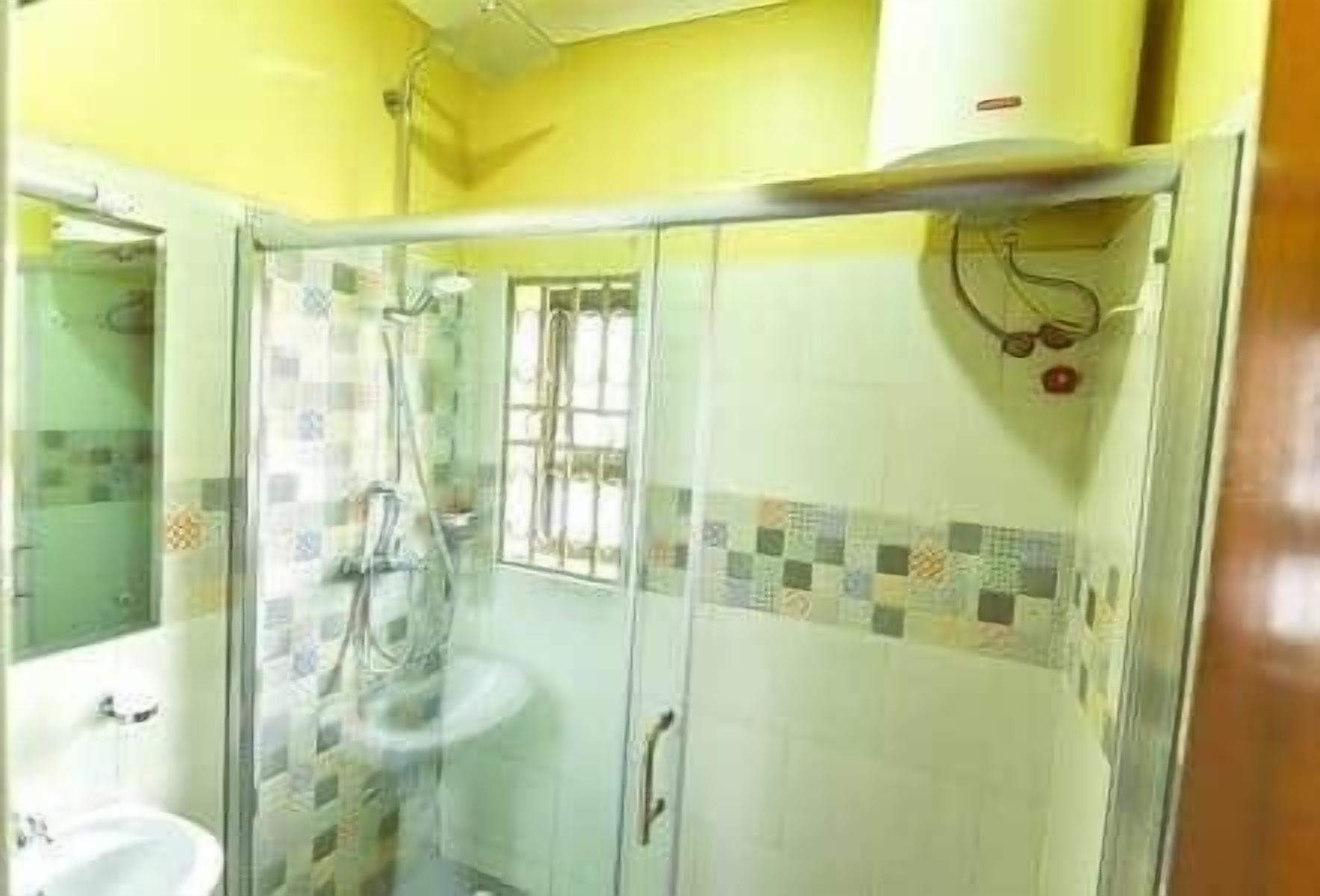 A bathroom with a glass shower enclosure, a sink, and a toilet.