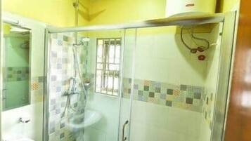 A bathroom with a glass shower enclosure, a sink, and a toilet.