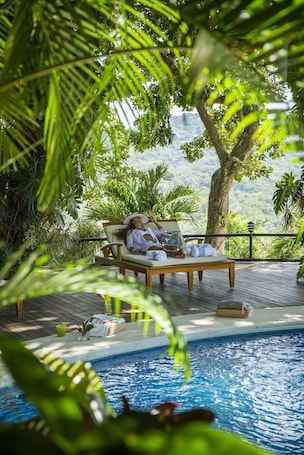 Una piscina al aire libre, sillones reclinables de piscina