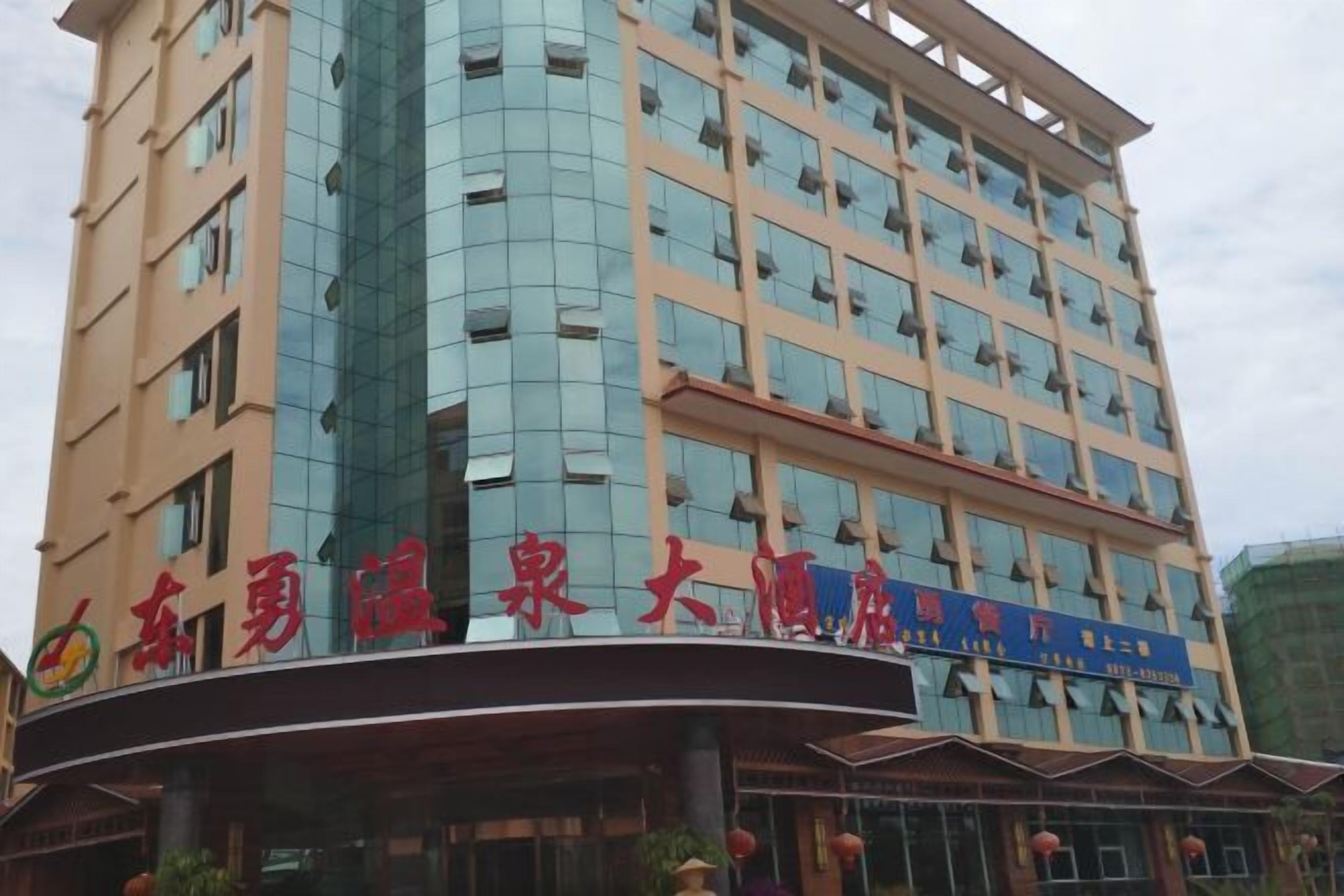 Un hotel de varios pisos con fachada curva y grandes ventanales.