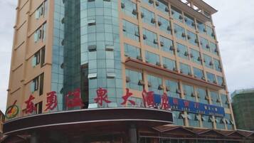 Un hotel de varios pisos con fachada curva y grandes ventanales.