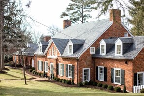 A row of brick houses with gabled roofs and white window shutters.