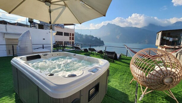 Een hottub op een terras met uitzicht op zee en bergen.