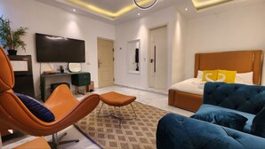 Een moderne hotelkamer met een groot bed, een televisie, een bureau en een comfortabele zithoek.