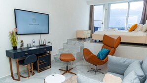 Une chambre d’hôtel moderne équipée d’un lit, d’un bureau, d’une chaise et d’un canapé.