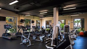 Et træningscenter med løbebånd, crosstrainere og styrkeudstyr.