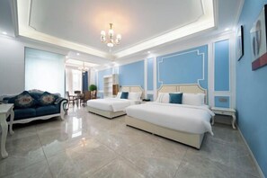 A hotel room with two beds, a sofa, a chandelier, and a blue accent wall. - Zhengyang Yunji City Hotel (Chongqing Baguocheng) (Chongqing)