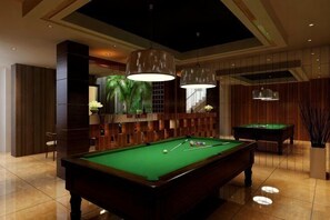 Een pooltafel in een kamer met een hoge plafond, ingebouwde verlichting en een modern design.