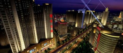 A high-rise hotel with multiple floors, a prominent entrance, and a surrounding urban landscape.