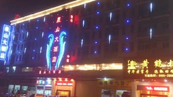 Un edificio con señalización iluminada y varios pisos, probablemente un hotel o establecimiento comercial.