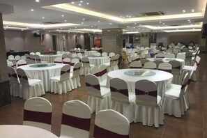 A banquet hall with round tables and chairs, arranged in rows. - Quan Shan Hotel (Quanzhou)