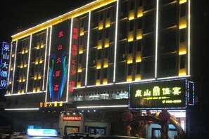 A hotel with multiple floors, illuminated signage, and a prominent entrance.