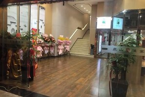 A hotel lobby with a staircase, potted plants, and a reception desk. - Quan Shan Hotel (Quanzhou)