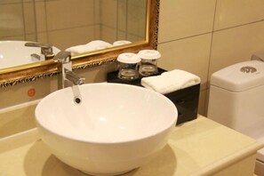 A bathroom with a white sink, a mirror, and a toilet. - Quan Shan Hotel (Quanzhou)