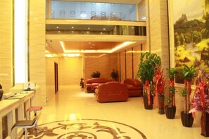 A hotel lobby with a reception desk, seating area, and potted plants. - Quan Shan Hotel (Quanzhou)