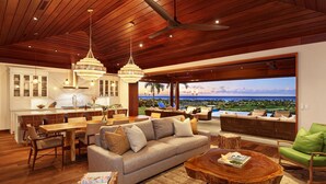 A spacious living area with a wooden ceiling, a large sofa, and a dining table. - Panoramic Ocean Views From Private Gated Estate (Kaloa)