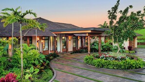 A modern building with a curved driveway, surrounded by lush greenery and palm trees. - Panoramic Ocean Views From Private Gated Estate (Kaloa)