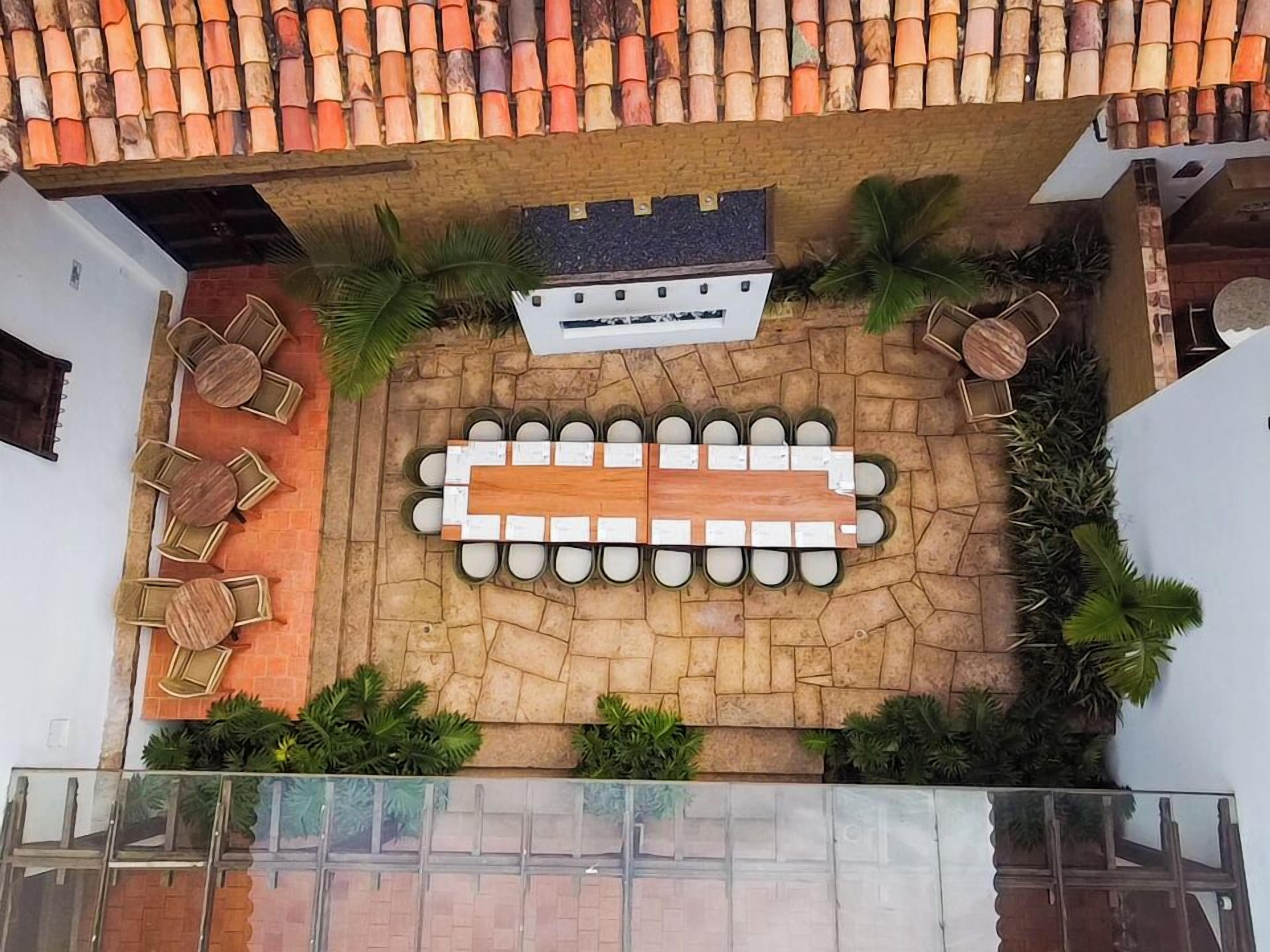 Un patio con muro de piedra, mobiliario exterior y una parrilla pequeña.