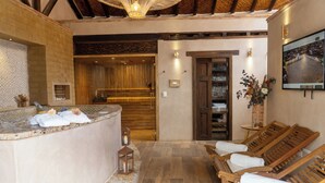 Un área de spa con mostrador de recepción, sillones de madera, suelo de piedra y techo de madera.