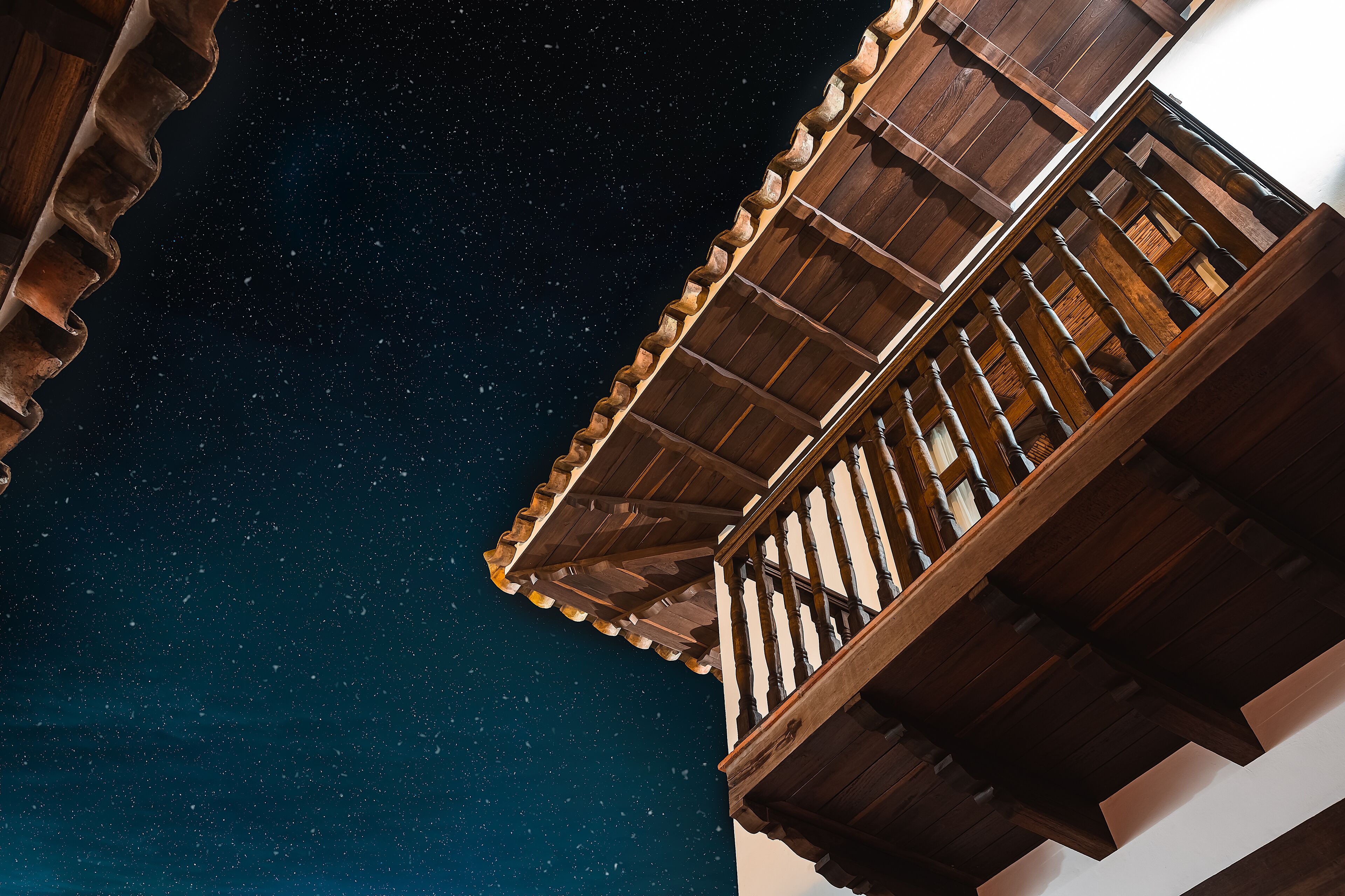 Un balcón de madera con vistas al cielo nocturno.