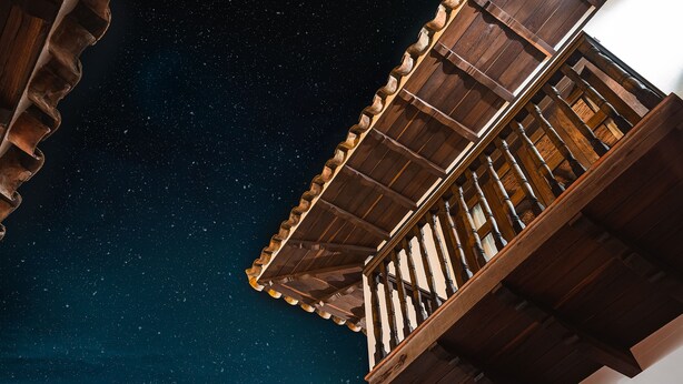 Un balcón de madera con vistas al cielo nocturno.