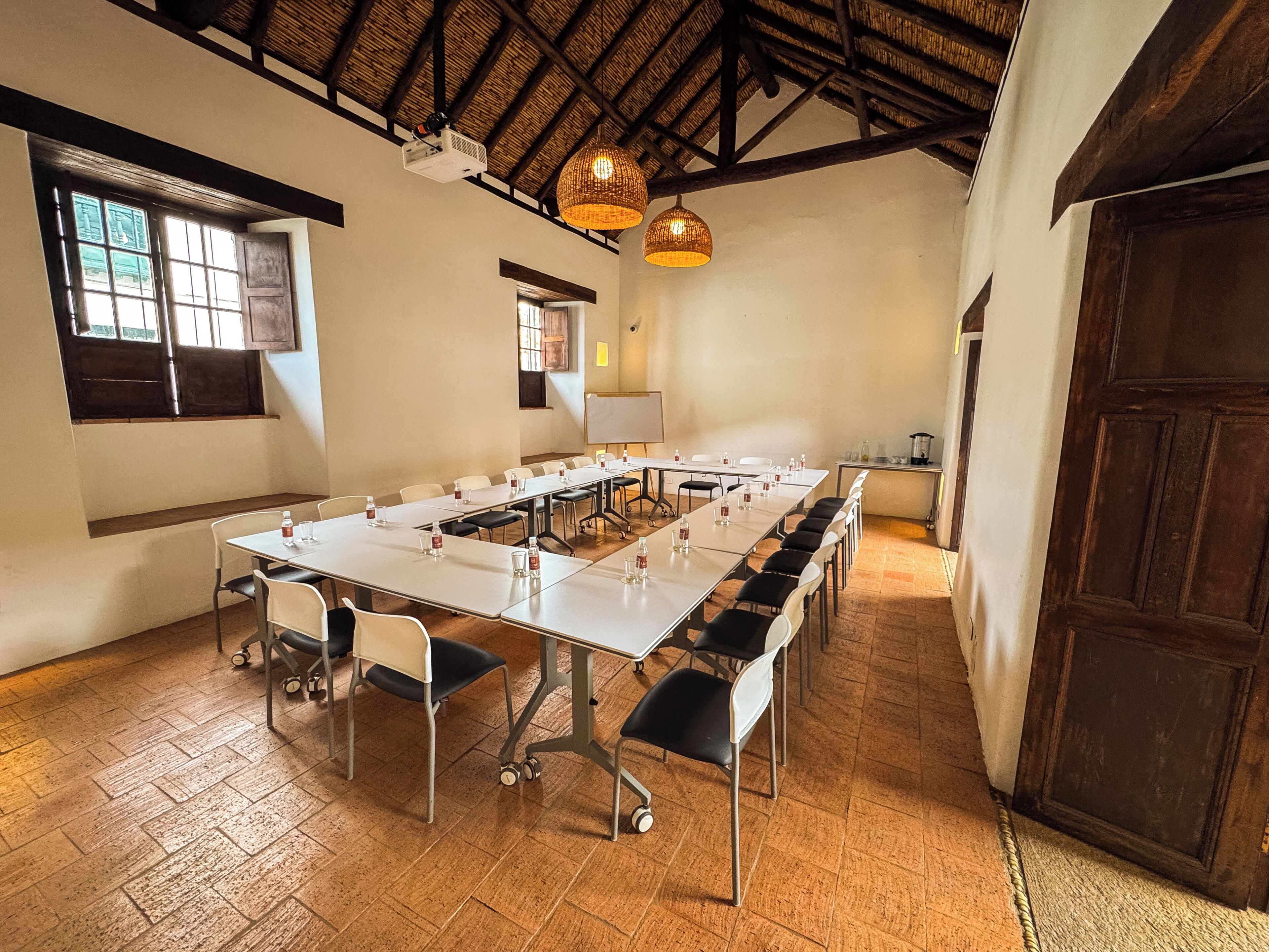 A conference room with a long table, chairs, a projector, and a whiteboard.