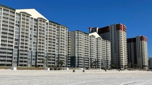 Un hôtel de grande hauteur, avec de nombreux étages, de grandes fenêtres et un toit plat.