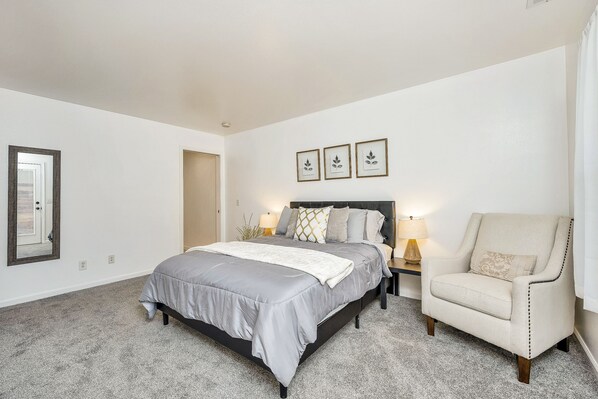 A bedroom with a bed, a chair, and a nightstand. - Modern Home in downtown Middletown! Walk to shops & restaurants! (Middletown)