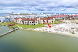 A coastal residential area with multi-story buildings, a pier, and a beach.